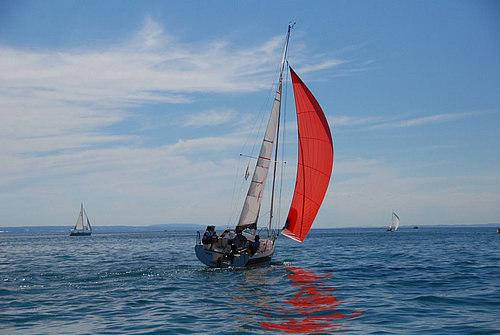 Segelyacht Bente 24 mit geblähtem roten Segel auf Bodensee
